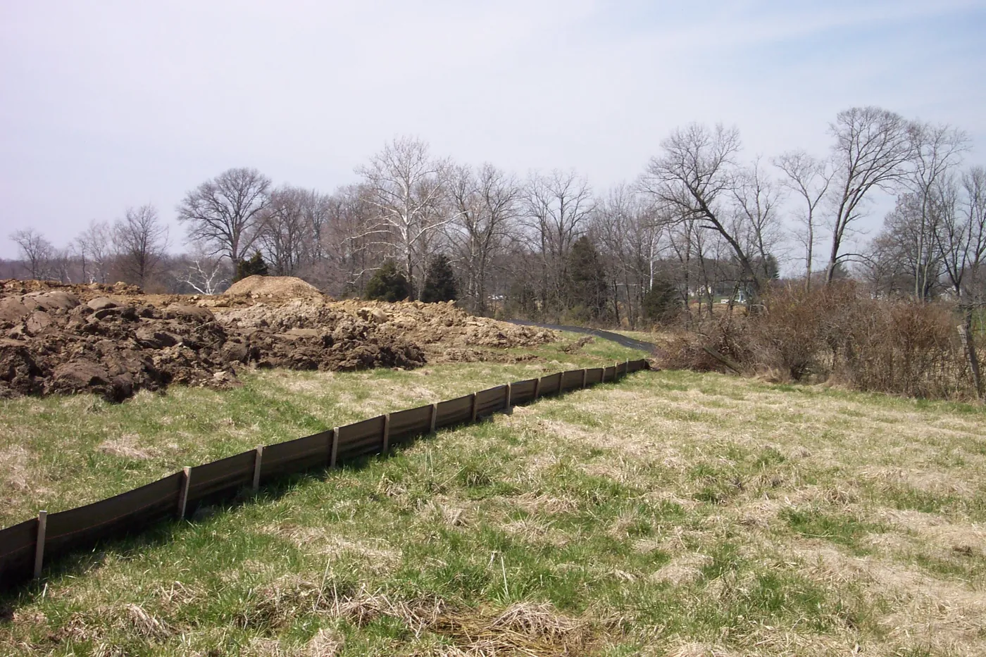 Silt fence staked along the edge of a graded construction site